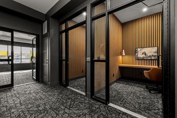 A room with a wooden panelled wall and a grey carpet.